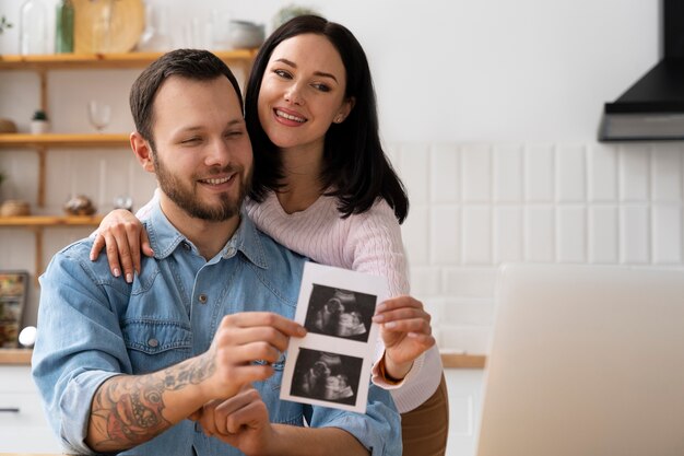 Medium shot couple holding ultrasound