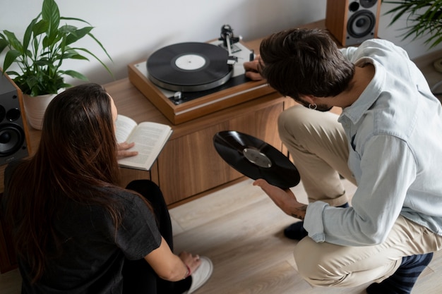 Medium shot couple at home with music