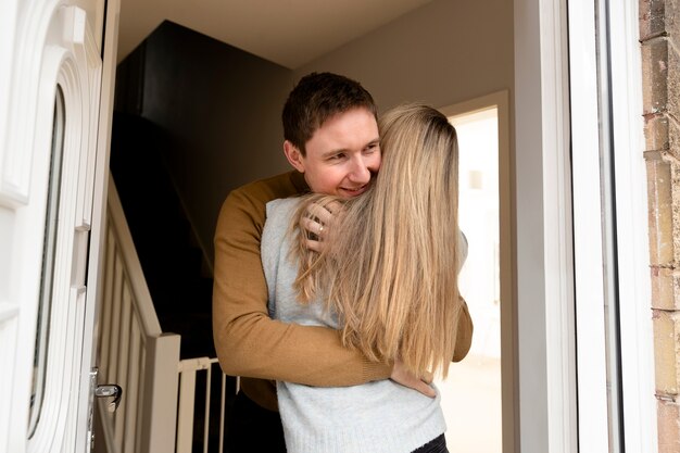 Medium shot couple hugging after long time