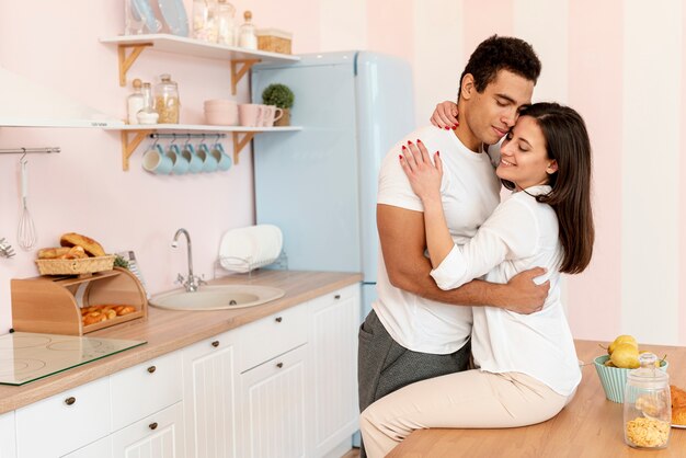 Medium shot couple hugging in the kitchen