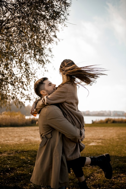 Medium shot couple hugging outdoors