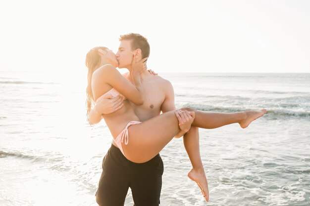 Medium shot couple kissing on beach