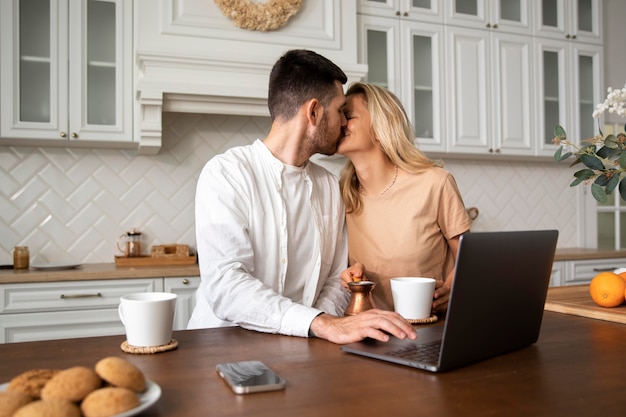 Free photo medium shot couple kissing in kitchen