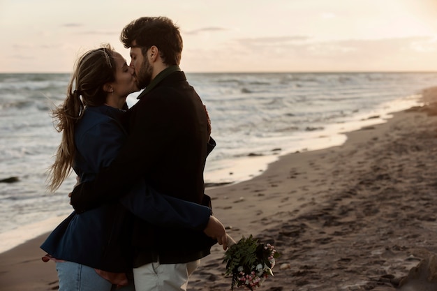 Foto gratuita coppia di tiro medio che si bacia al mare