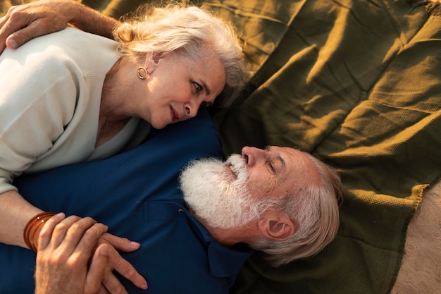 Free photo medium shot couple laying on cloth