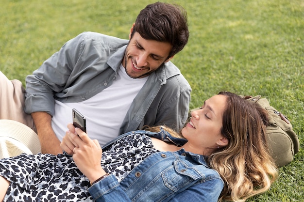 Free photo medium shot couple laying on grass