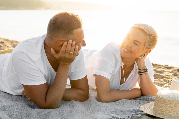 Medium shot couple laying on towel