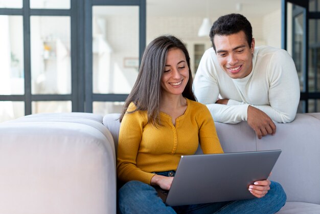 Medium shot of couple looking at laptop