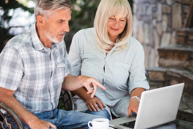 Medium shot couple looking at laptop