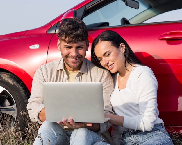 Free photo medium shot couple looking at laptop