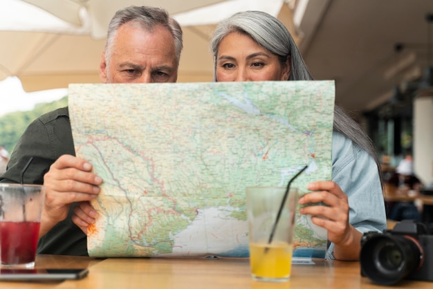 Free photo medium shot couple looking at map