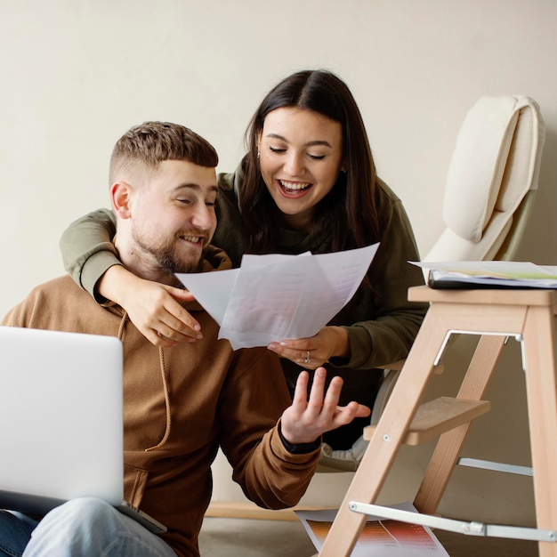 Medium shot couple looking at plans