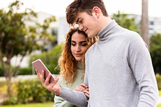 Free photo medium shot couple looking at smartphone