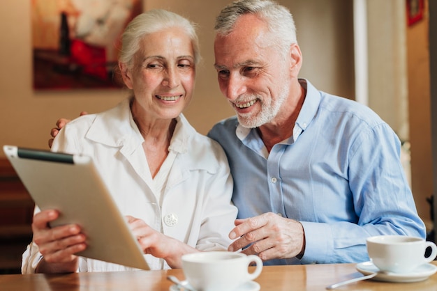 Medium shot couple looking at a tablet