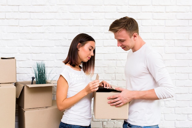 Free photo medium shot couple opening a box