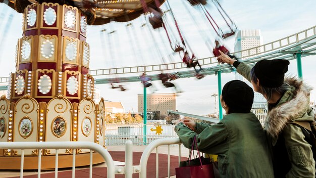 Medium shot couple pointing at carousel