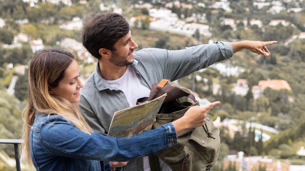 Medium shot couple pointing at town