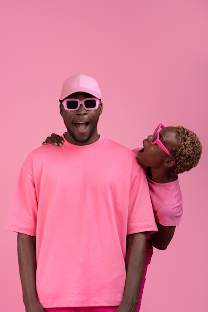 Free photo medium shot couple posing with pink outfit