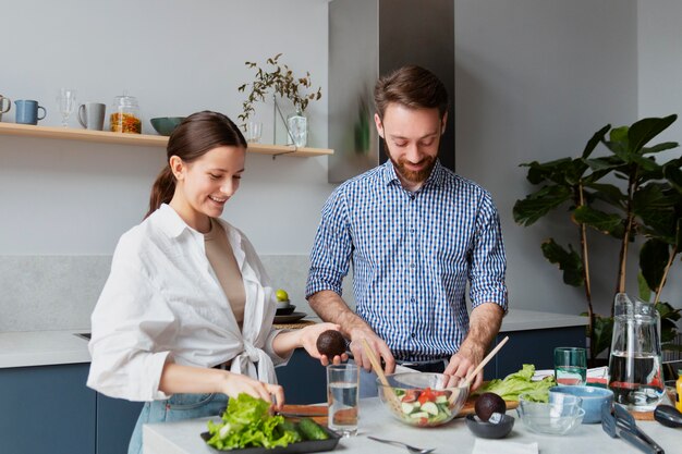 Medium shot couple preparing food in kitchen