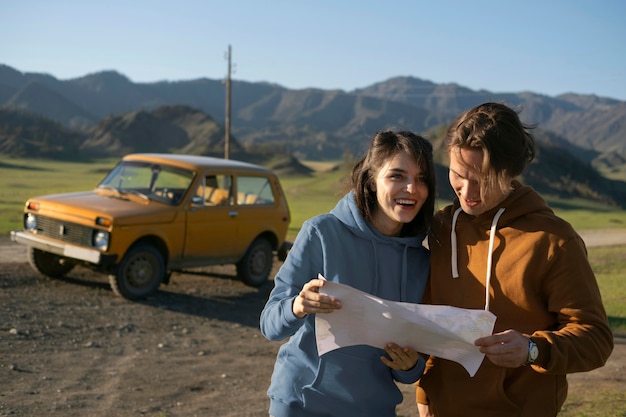 Free photo medium shot couple reading map