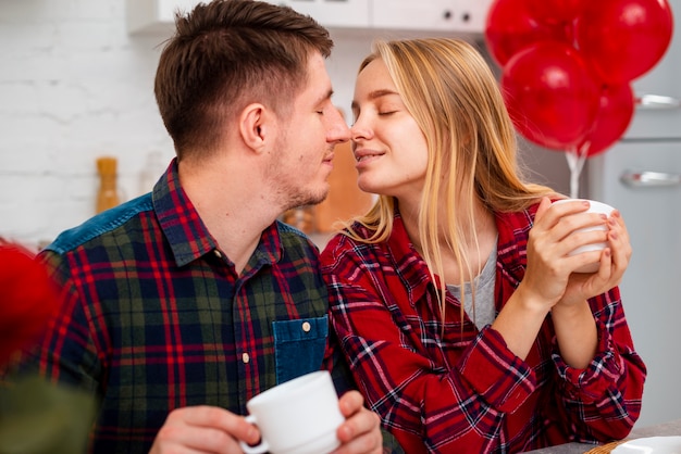 Free photo medium shot couple romantic gesture in the kitchen