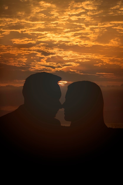 Siluette delle coppie del colpo medio al tramonto