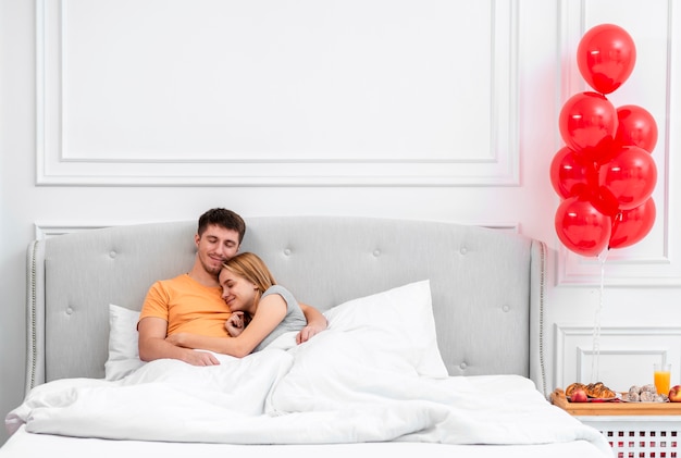 Medium shot couple sitting in bed