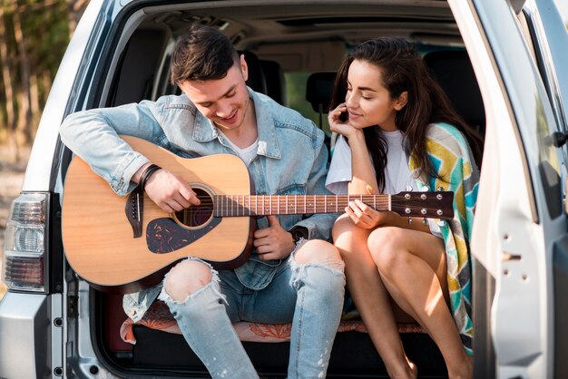 Medium shot couple sitting in trunk