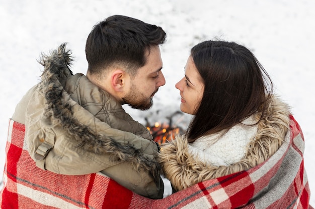 Free photo medium shot couple sitting with blanket