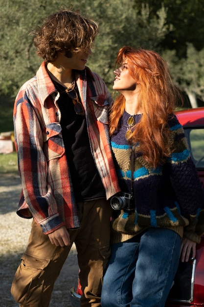 Medium shot couple standing near car