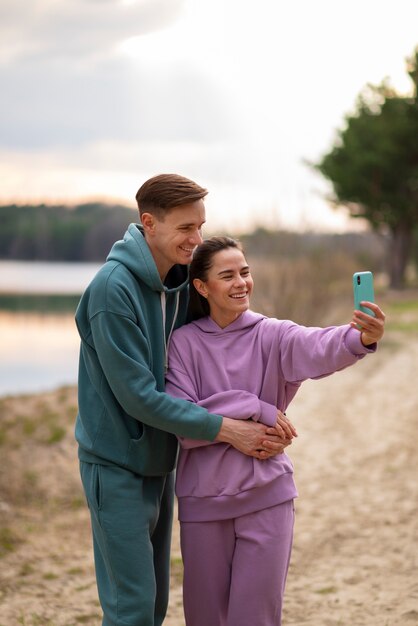 Medium shot couple taking selfie