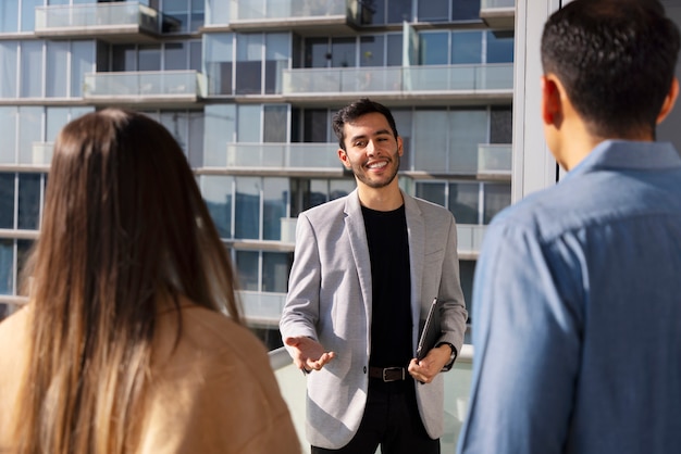 medium shot couple talking to real estate agent
