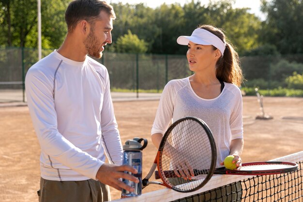 Medium shot couple on tennis court