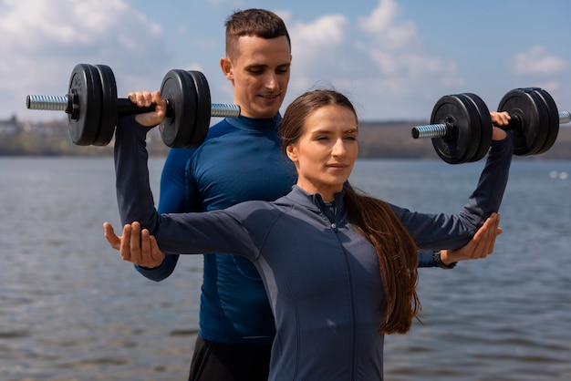 Medium shot couple training together outdoors