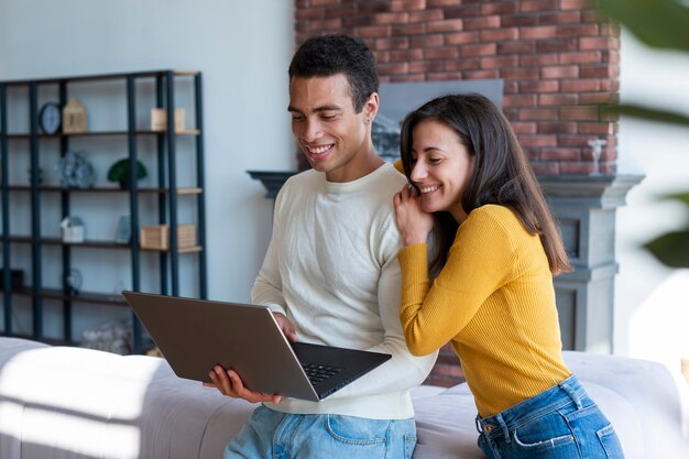 Medium shot of couple using laptop