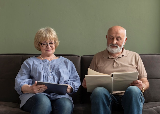 Medium shot couple with book and tablet