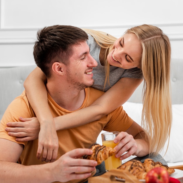 Medium shot couple with breakfast in bed