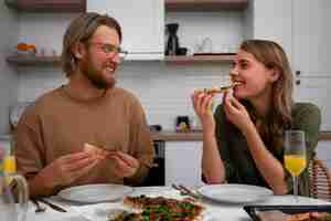 Free photo medium shot couple with delicious pizza