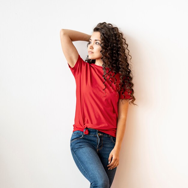 Medium shot curly woman in red t-shirt posing