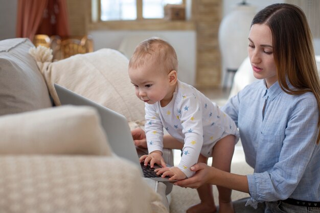 Bambino sveglio del colpo medio che scrive sul computer portatile