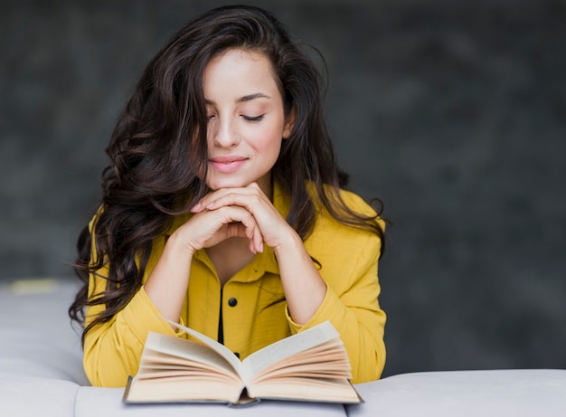 Medium shot cute brunette girl reading