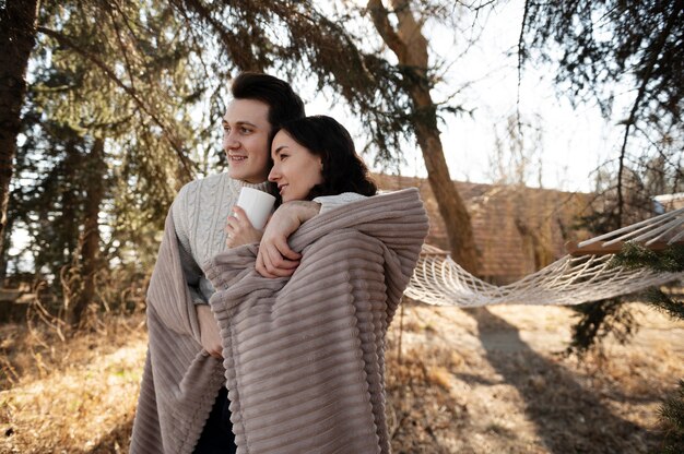 Medium shot cute couple under blanket