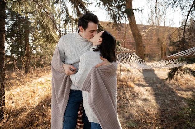 Medium shot cute couple kissing in nature