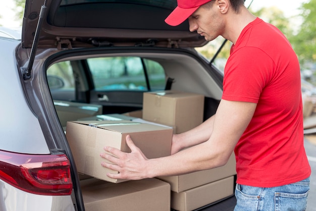 Free photo medium shot delivery guy arranging boxes