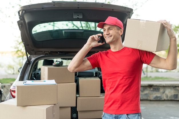 Medium shot delivery guy talking on phone