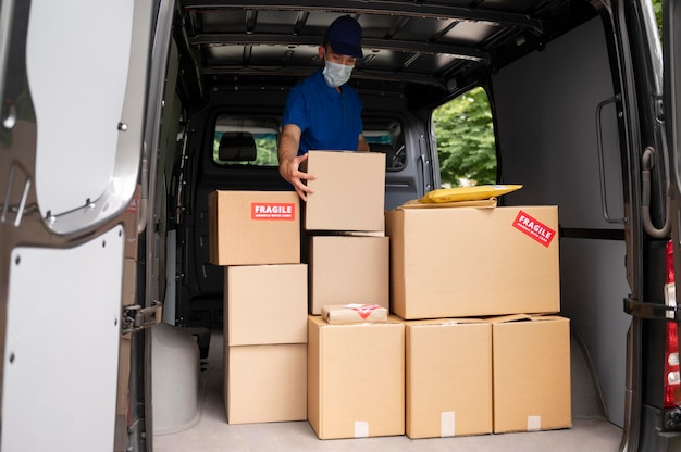 Medium shot delivery man carrying box