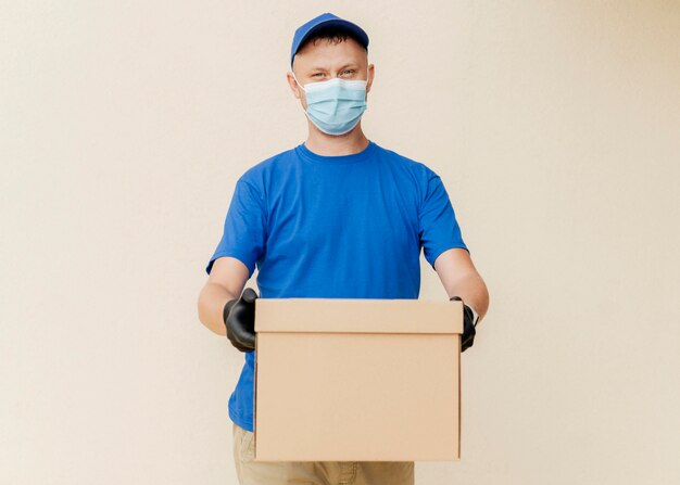 Medium shot delivery man holding box