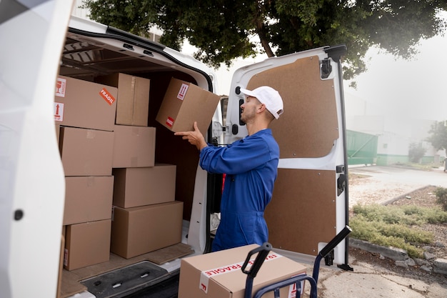 Free photo medium shot delivery man holding pack