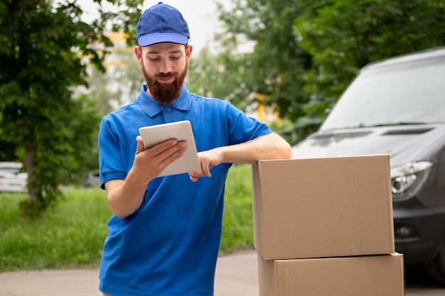 Medium shot delivery man holding tablet