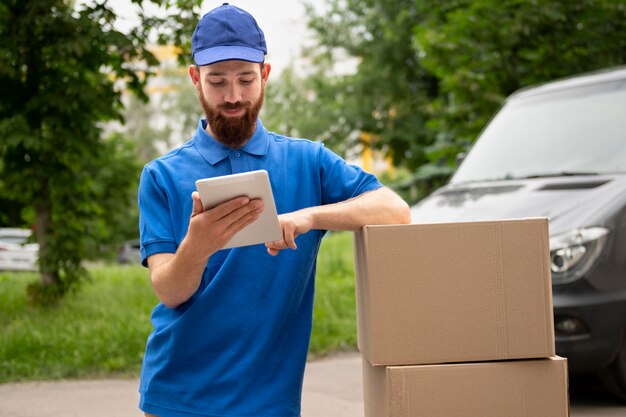 Medium shot delivery man holding tablet